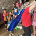 Kids dressed in hero capes and masks coming down the main stairs at Peace Tohickon Lutheran Church during Hero Central Vacation bible School